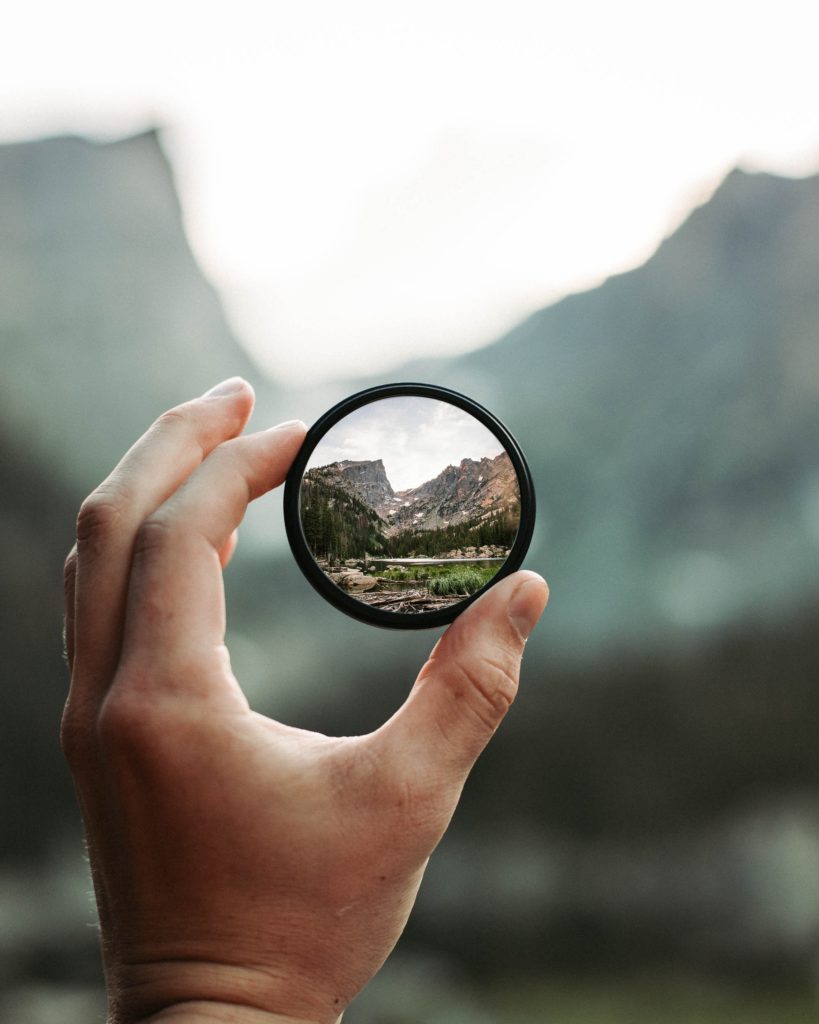 man holding telescope lens.